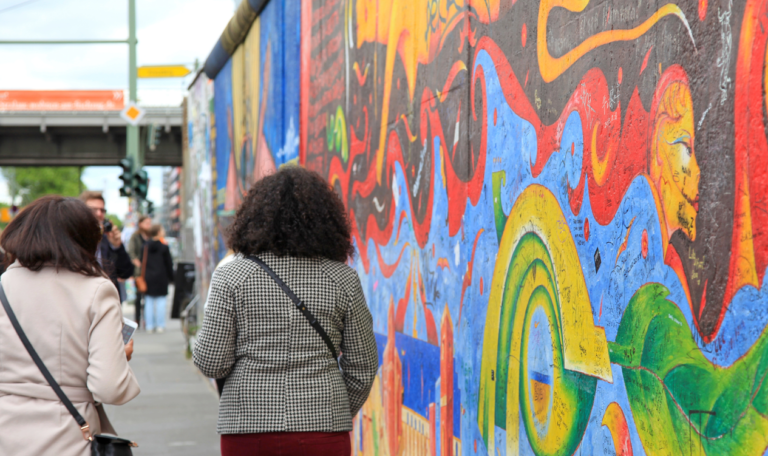 Zwei Frauen laufen entlang der Eastside Gallery