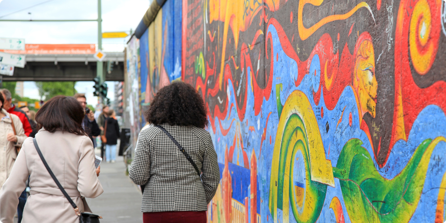 Zwei Frauen laufen entlang der Eastside Gallery