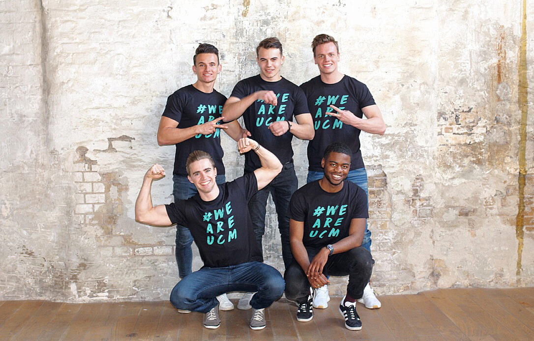 Fünf junge Männer mit schwarzen ucm T-Shirts posieren lustig