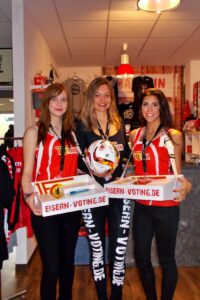 Drei Promoter:innen bewerben den 1. FC Union Berlin vor einem Store